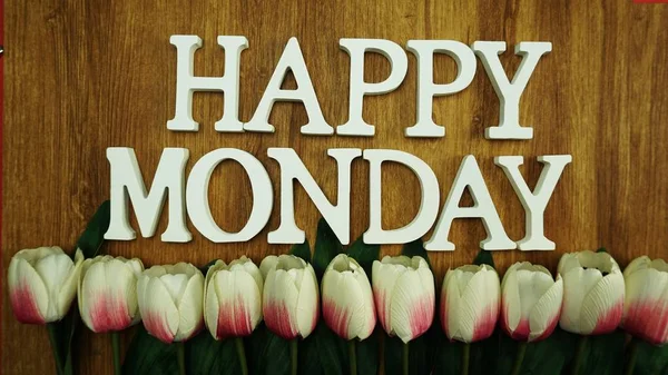 Happy Monday Word on Light box with tulip flower bouquet on wooden background