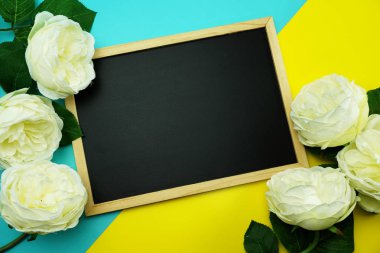 yazı tahtası ve düz mavi ve sarı zemin üzerine Şakayık Çiçeği demet