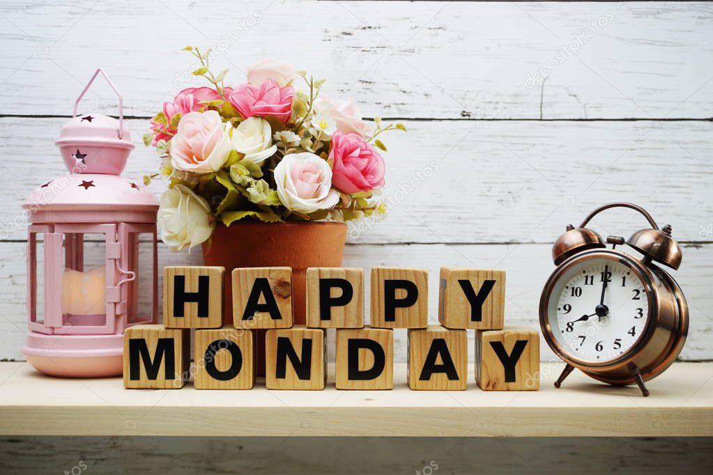 Happy Monday Word on Light box with roses flower bouquet on wooden background