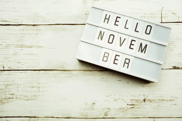 Top View Hello November alphabet letters with light box on wooden background