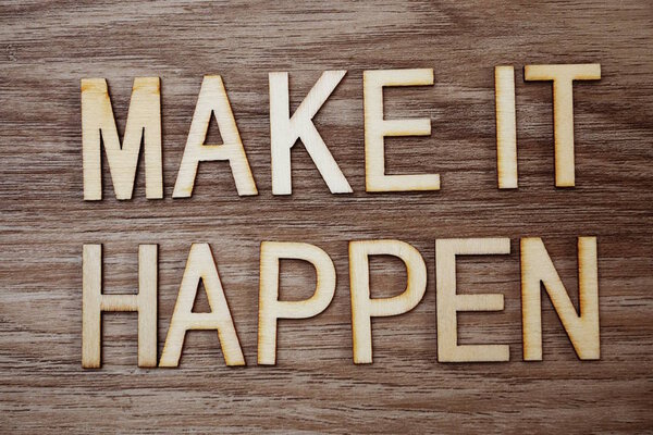 Make It Happen текстовое сообщение на деревянном фоне
