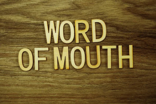 Word Of Mouth text message on wooden background