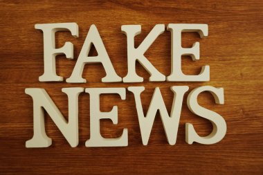 Sahte haber kelime alfabesi harfleri ahşap arka plan üzerinde