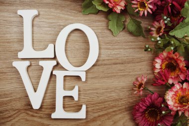 Sevgililer günü kavramı aşk alfabesi ile ahşap arka plan üzerinde çiçek