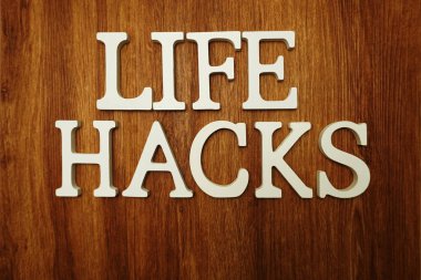 Ahşap arka plan üzerinde Life Hacks kelime alfabesi harfleri