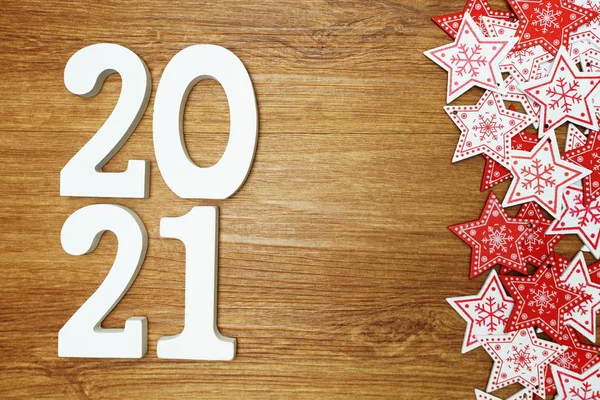 2021 happy new year with white and red star ornament decoration on wooden background