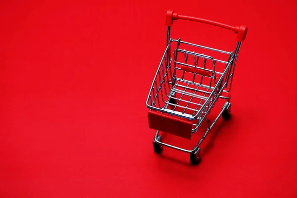 Mini Einkaufswagen Auf Rotem Hintergrund — Stockfoto