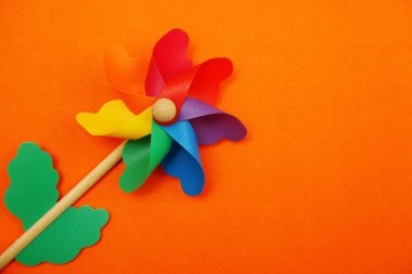 Turuncu arka planda izole edilmiş alan kopyasına sahip renkli fırıldak