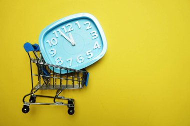 Sarı arka plan üzerinde alan kopyası ile çalar saat ve mini tramvay arabası