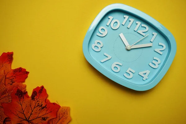 Relógio Alarme Bordo Laranja Deixa Sobre Fundo Amarelo — Fotografia de Stock