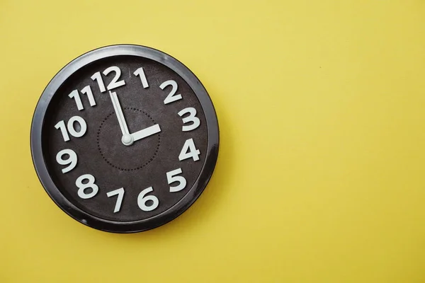 Чёрные Круглые Часы Жёлтом Фоне Одиннадцать Часов — стоковое фото