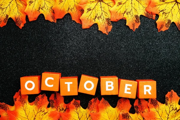 黒の輝きの背景にオレンジ色のアルファベット10月の文字 — ストック写真
