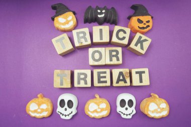 Cadılar Bayramı konsepti düz yatıyordu mor arkaplan üzerinde şaka mı şeker mi alfabesi harfleri