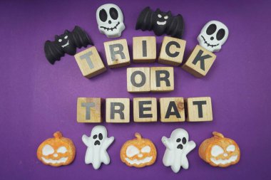 Cadılar Bayramı konsepti düz yatıyordu mor arkaplan üzerinde şaka mı şeker mi alfabesi harfleri