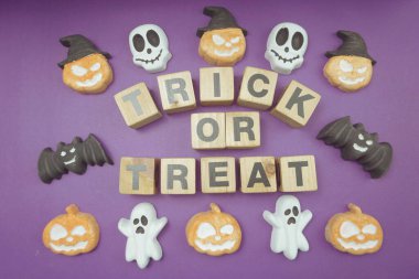 Cadılar Bayramı konsepti düz yatıyordu mor arkaplan üzerinde şaka mı şeker mi alfabesi harfleri