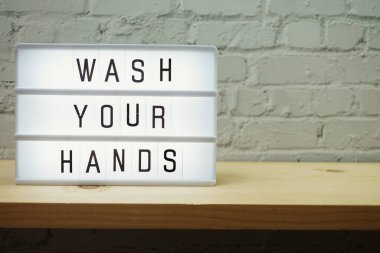 Beyaz tuğlalar ve ahşap raflar üzerinde yer nazlı ışık kutusunda ellerinizi yıkayın.