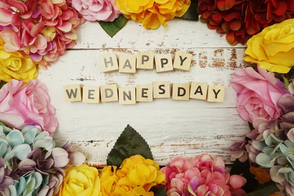 木製の背景にカラフルな花のボーダーフレームと幸せな水曜日のアルファベット文字 — ストック写真