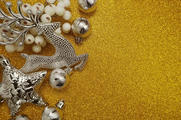 Silver Christmas ornaments with Christmas balls and elk dedcoration with space copy on gold glitter background