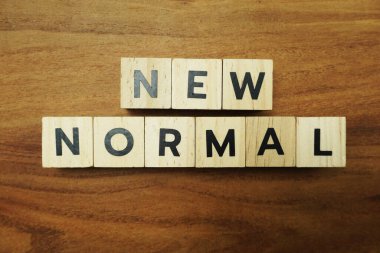 Ahşap arkaplanda Yeni Normal alfabe harfleri