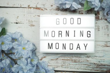 Günaydınlık kutuda günaydın. Ahşap arka planda çiçek süslemesi var.