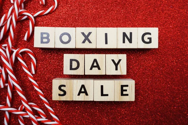 Boxing Day Sale alphabet letter with candy cane decoration on red glitter background