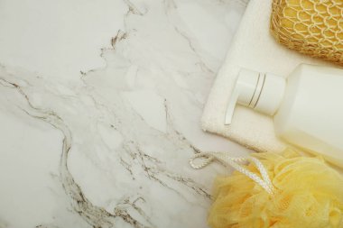 Duş aksesuarları banyo malzemeleri duş şişesi, sünger ve lif mermer arka planda.