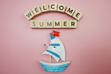 Hoş geldiniz. Pembe arka planda yelkenli teknesi olan yaz mesajı alfabesi mektubu.