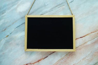 Mermer duvar dokusu arka planında boş siyah tahta