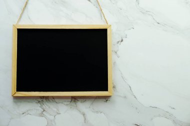 Mermer duvar dokusu arka planında boş siyah tahta