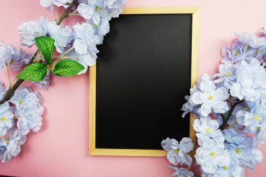 Pembe arka planda uzay siyah tahtası ve çiçek buketi dekorasyonu