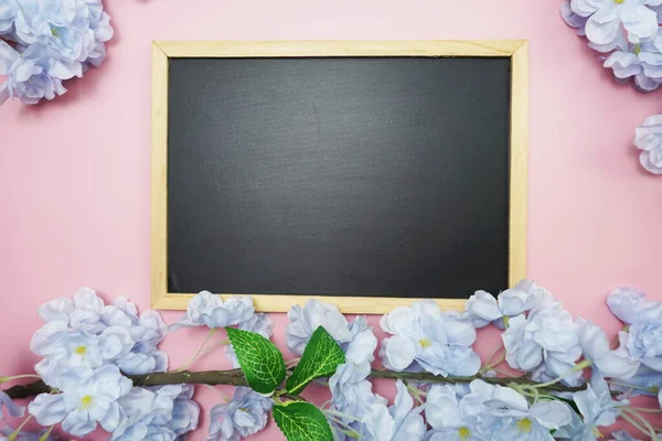 Pembe arka planda uzay siyah tahtası ve çiçek buketi dekorasyonu