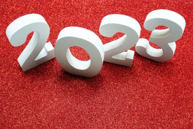 2023 Mutlu Yıllar, kırmızı parıltılı arka planda yer kopyası ile.