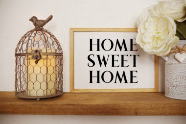 Home Sweet Home beyaz tahtaya yazılmış LED mum ışığı ve ahşap rafta kuş kafesi