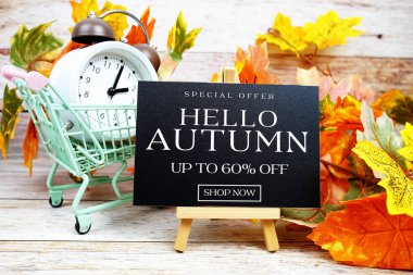 Sonbahar İndirimi% 60 indirimli Alarm saati ve ahşap arka planda akçaağaç yaprağı süslemeli Özel Teklif metni