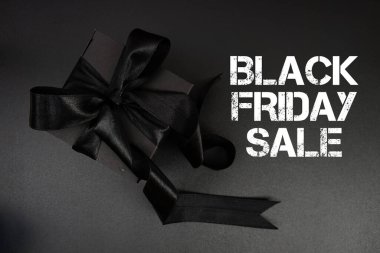 Siyah arkaplanda hediye kutusu olan Kara Cuma indirimi metni