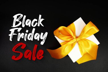 Siyah arkaplanda hediye kutusu olan Kara Cuma indirimi metni