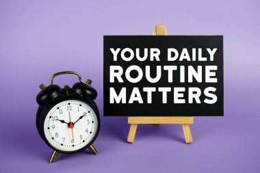 Günlük rutininiz Mor zemin üzerinde resim sehpası ve alarm saati olan metinleriniz