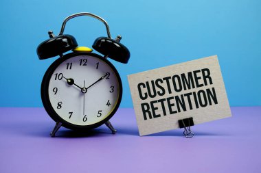 Customer Retention text with alarm clock on blue and purple background