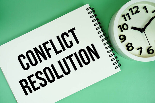 Conflict Resolution text with alarm clock flat lay on green background