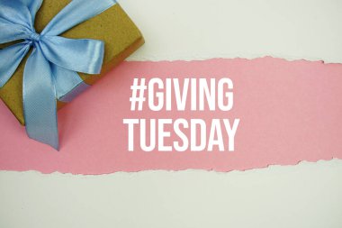 Giving Tuesday text with gift box present on pink background