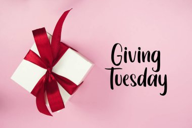 Giving Tuesday text with gift box present on pink background