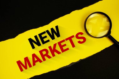 Yeni pazarlar sarı üzerine yazılar, yırtılmış siyah kağıt ve büyüteçle