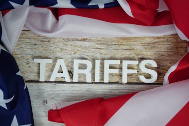 Ahşap arka planda ABD bayrağı bulunan tarifeler.