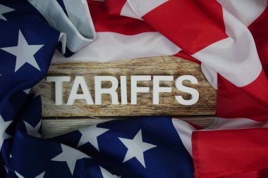 Ahşap arka planda ABD bayrağı bulunan tarifeler.