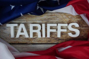 Ahşap arka planda ABD bayrağı bulunan tarifeler.