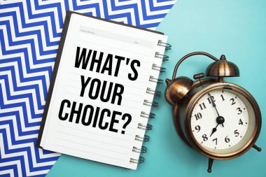 What's Your Choice? text written on notepad with alarm clock