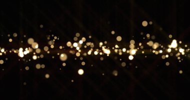 Altın ışık kıvılcımlar saçar, altın parıltı parıldar. Parlak kar bokeh bulanık efekti, parıldayan toz ışığı ve sihirli parıltı, Noel lüks arka planı