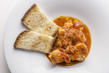 Kırmızı sos ve kızarmış ekmek rockfish güveç fileto balık plaka