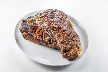 Bütün beyaz yuvarlak plakalı beyaz arka plan üzerinde izole T-bone biftek ızgara