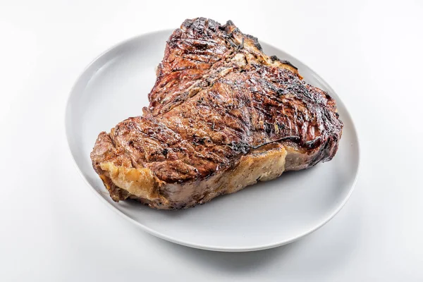Bütün beyaz yuvarlak plakalı beyaz arka plan üzerinde izole T-bone biftek ızgara